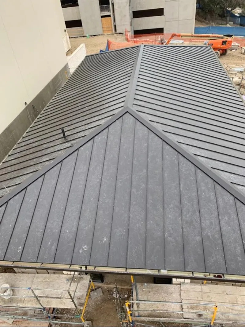 Commercial metal roof construction with crane equipment in Huron